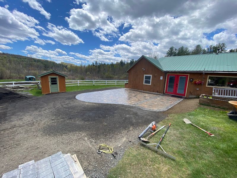A house with a green roof and a patio in front of it.