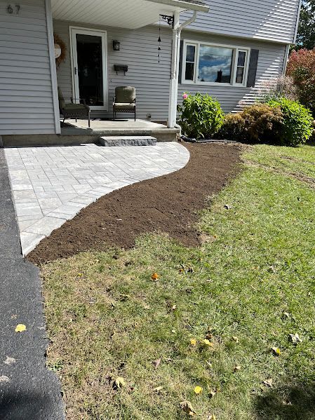 A house with a patio and a walkway in front of it.