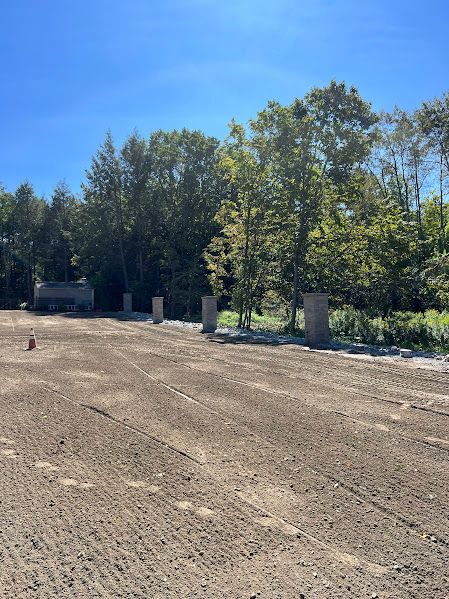 A large dirt field with trees in the background on a sunny day.