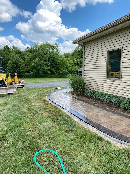 A hose is sitting in the grass in front of a house.