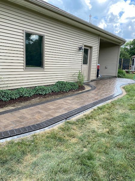 A house with a brick walkway leading to the front door.