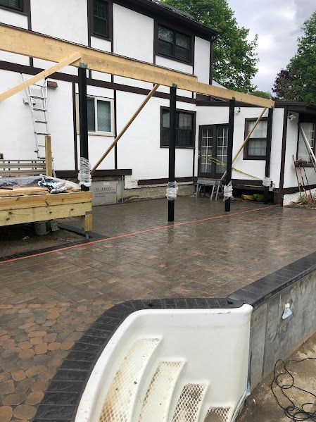 A white house with a swimming pool in front of it.