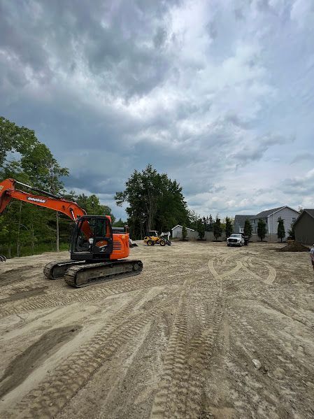 A large orange excavator is driving down a dirt road.