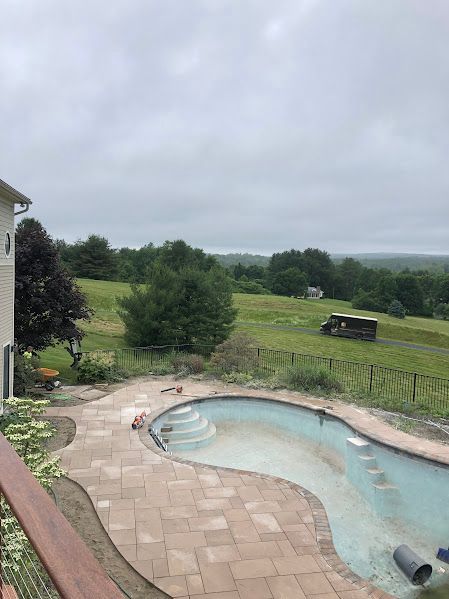 A large swimming pool is being built in the backyard of a house.
