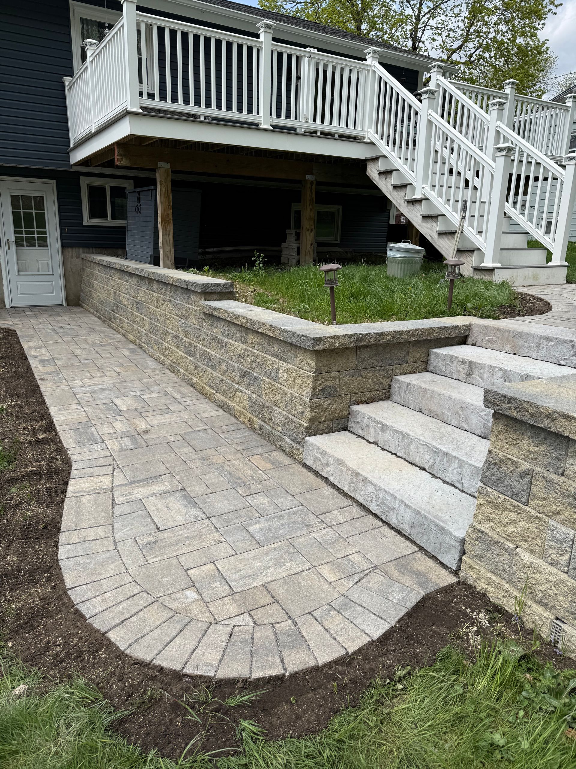 A brick walkway is leading to the front door of a house.