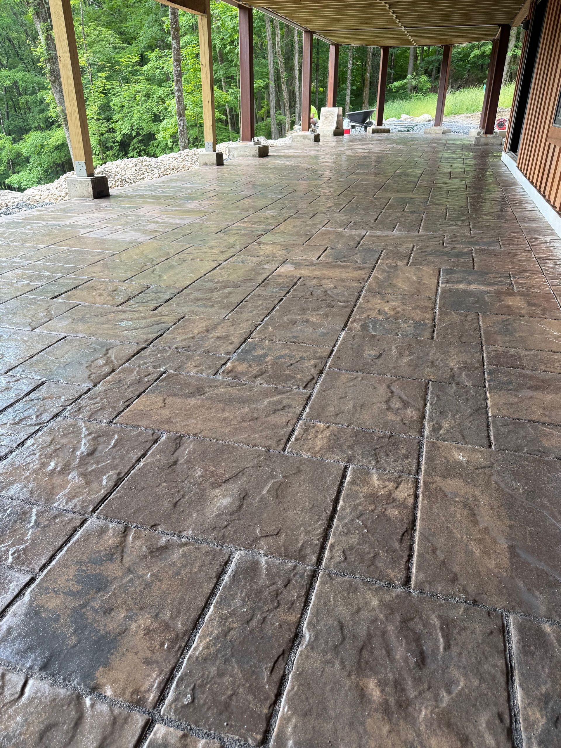 A large swimming pool is surrounded by a fence and a patio.