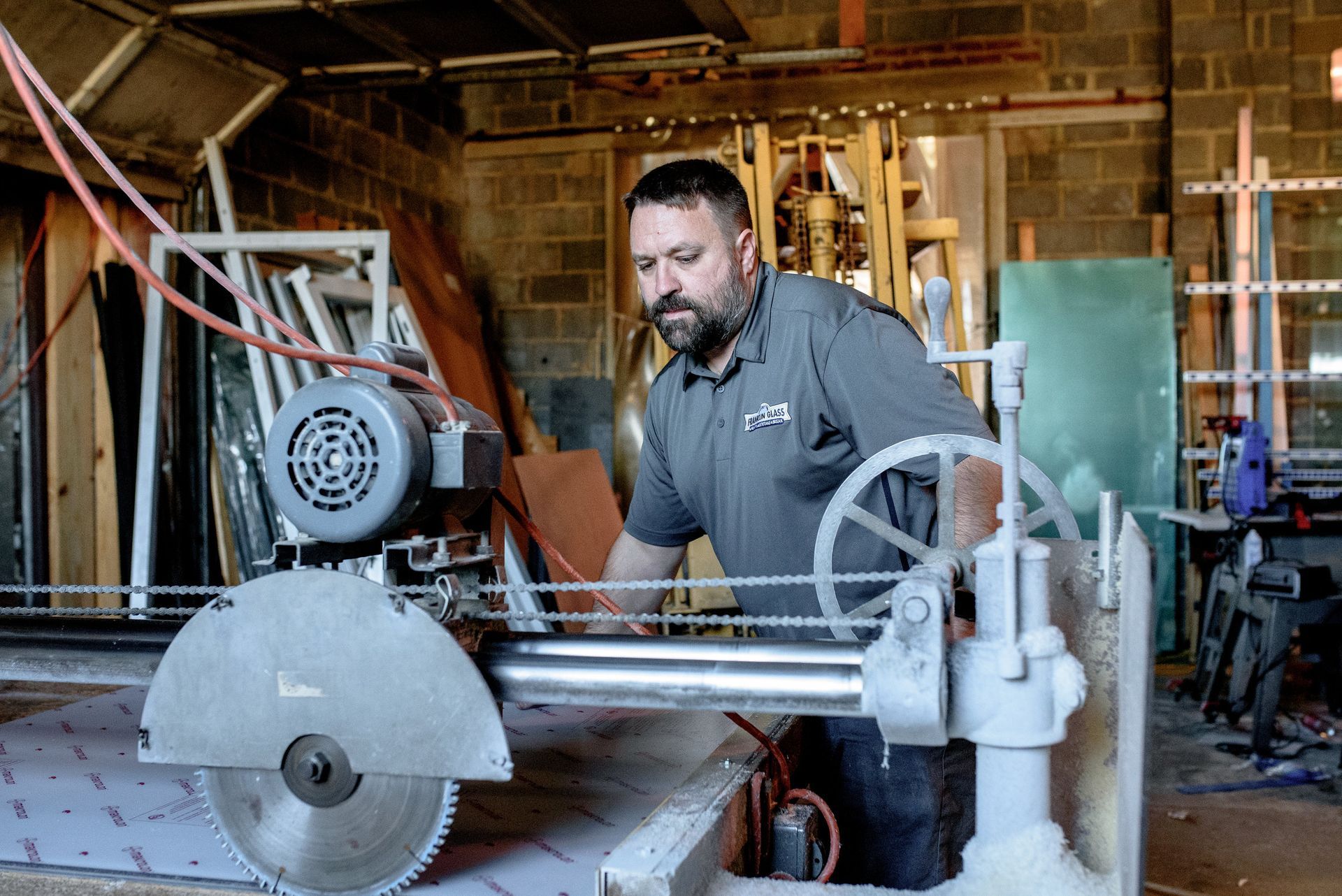 A man is using a circular saw to cut a piece of wood.