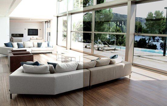A living room with a couch and chairs and a large window.