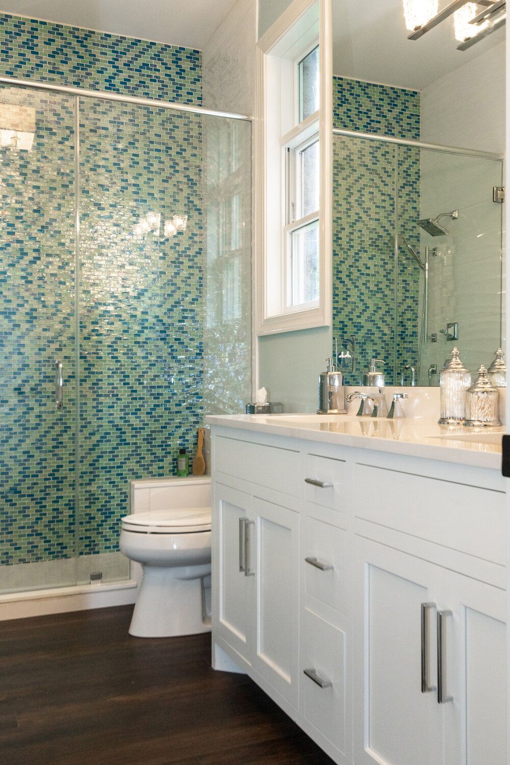 A bathroom with a toilet , sink , mirror and shower.