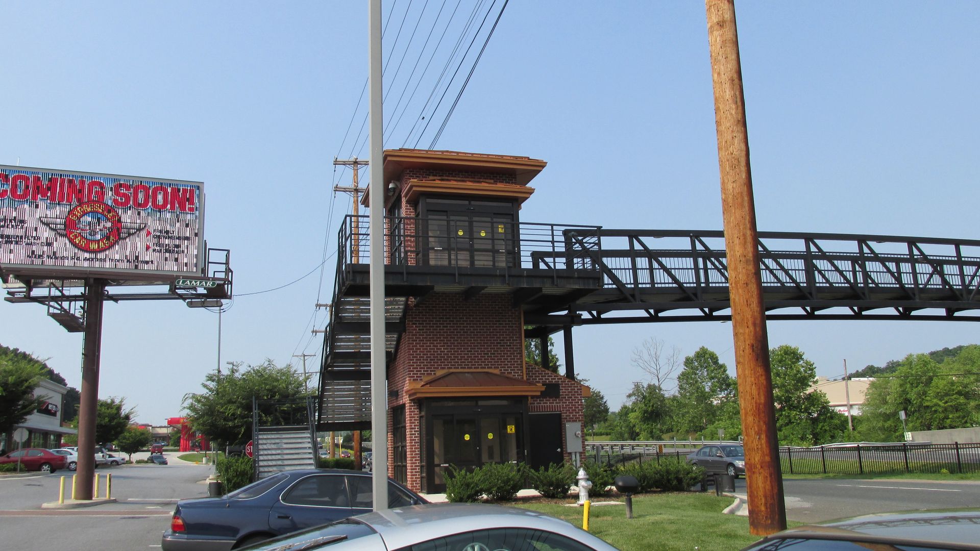 A car is parked in front of a sign that says coming soon