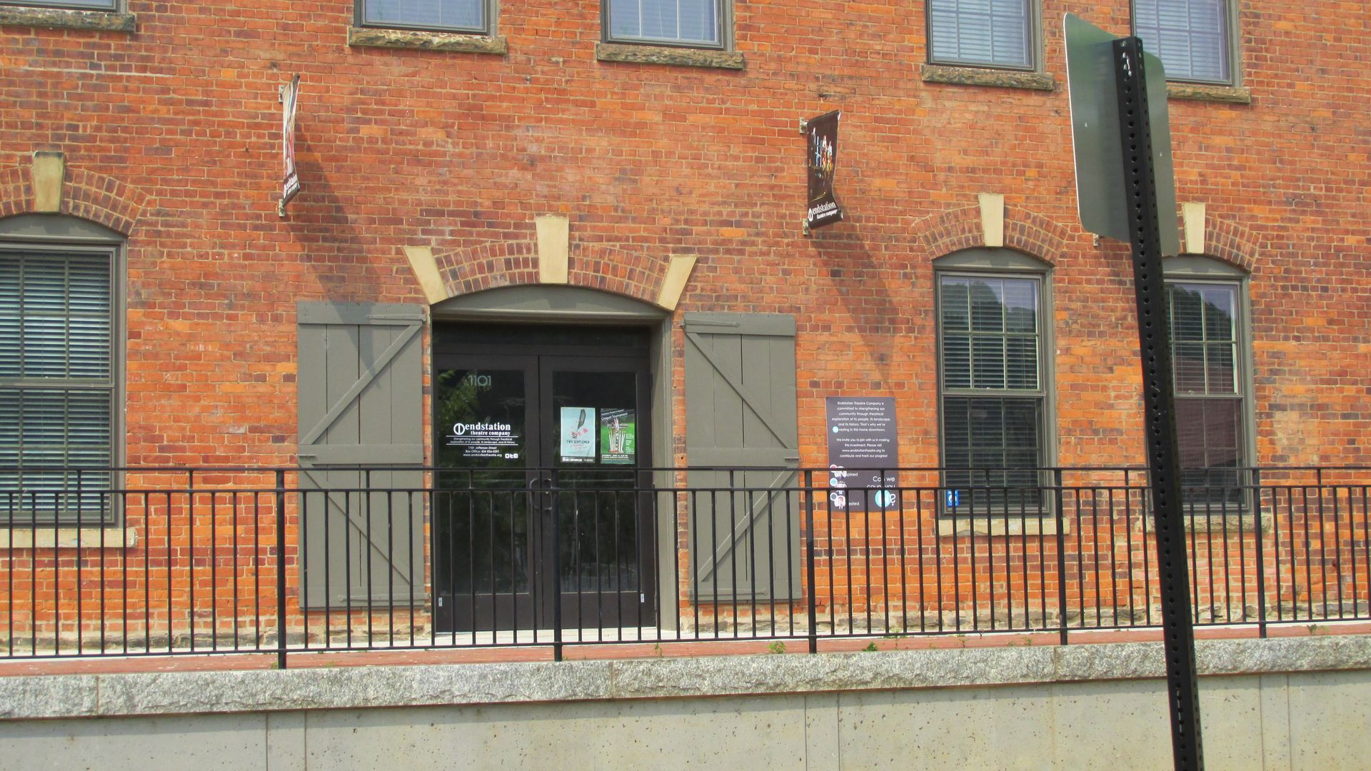 A brick building with a metal fence around it