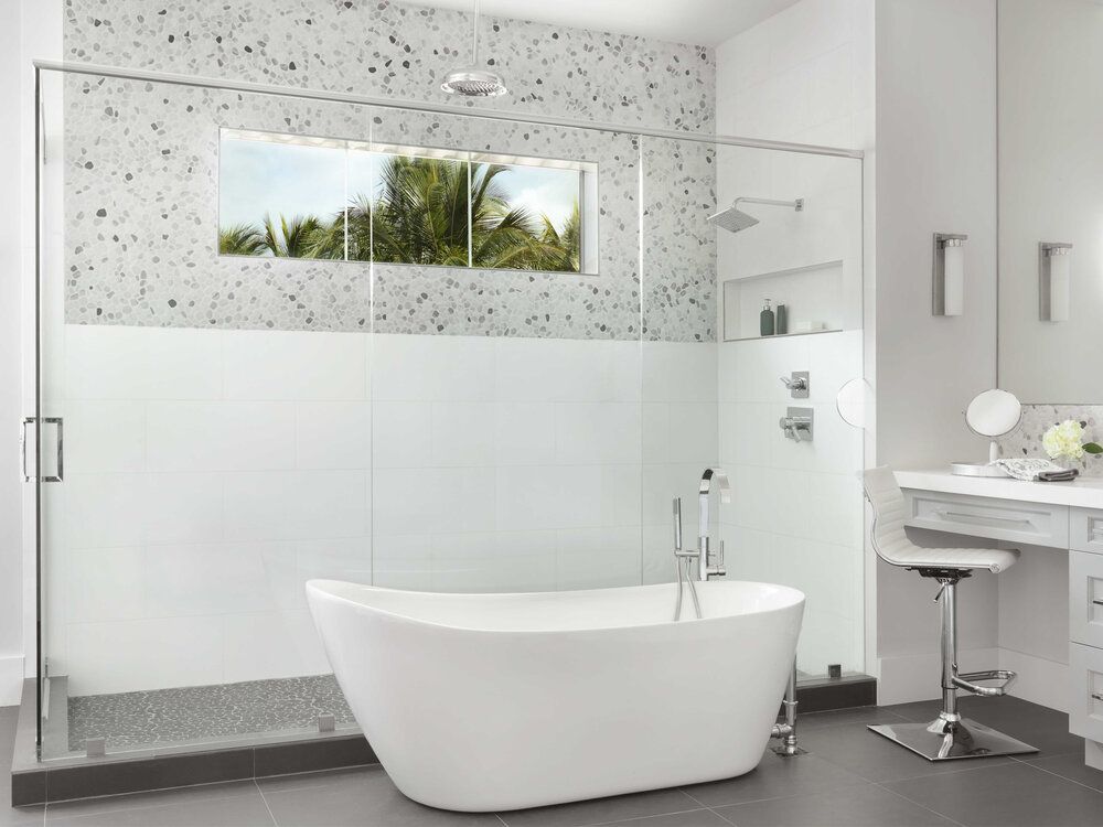 A bathroom with a tub , shower , sink and mirror.