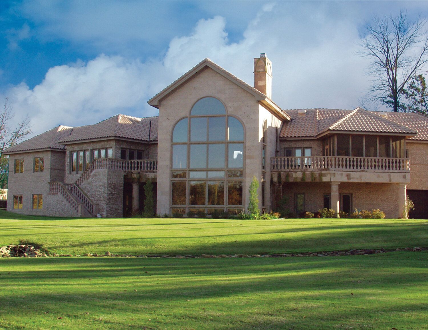 A large house with a lot of windows and a large lawn in front of it