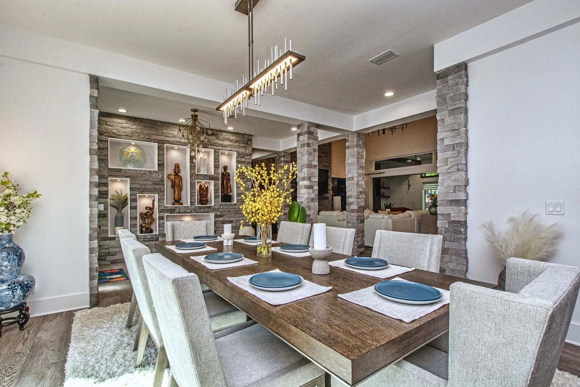A dining room with a long table and chairs and a chandelier.