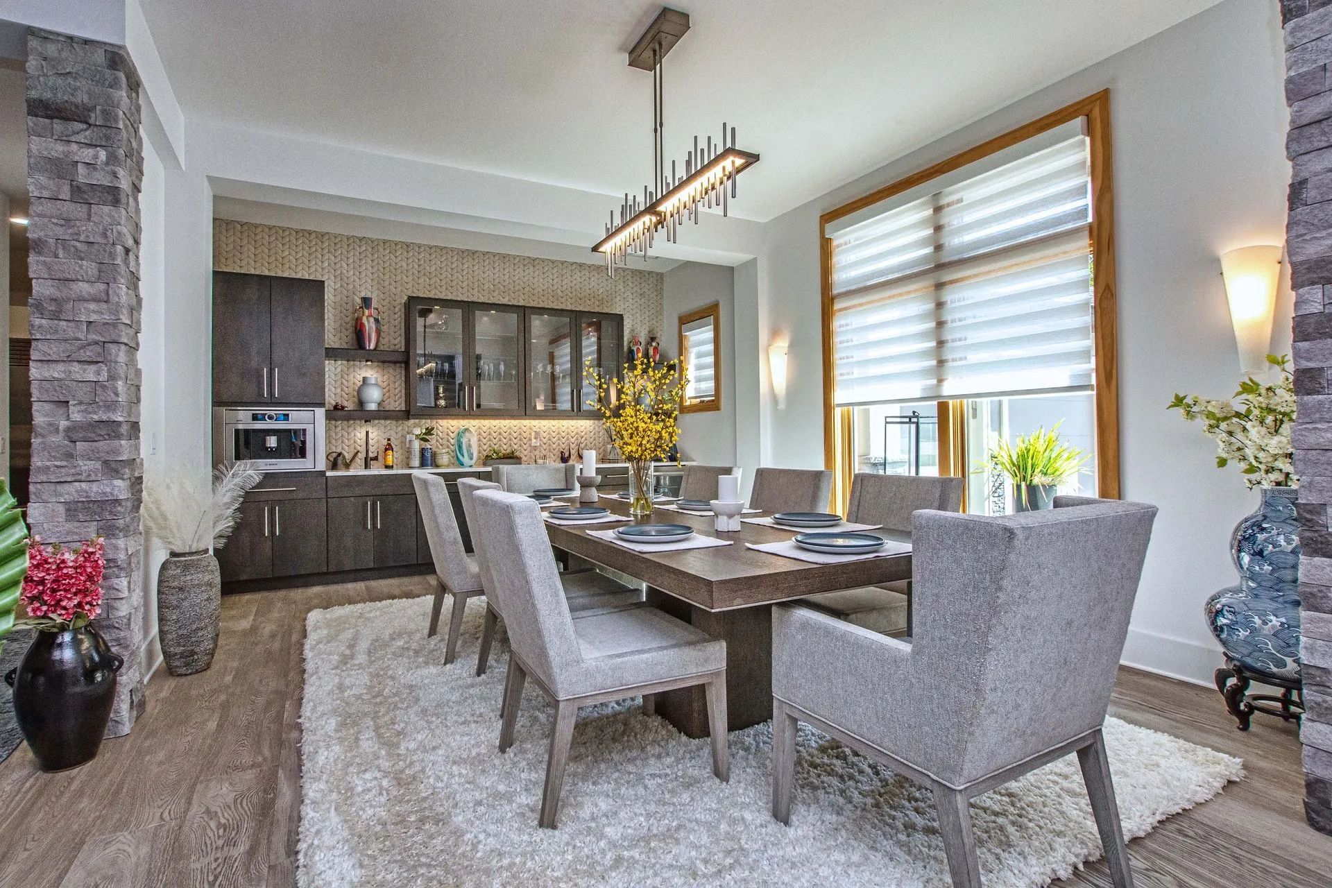A dining room with a table and chairs and a rug