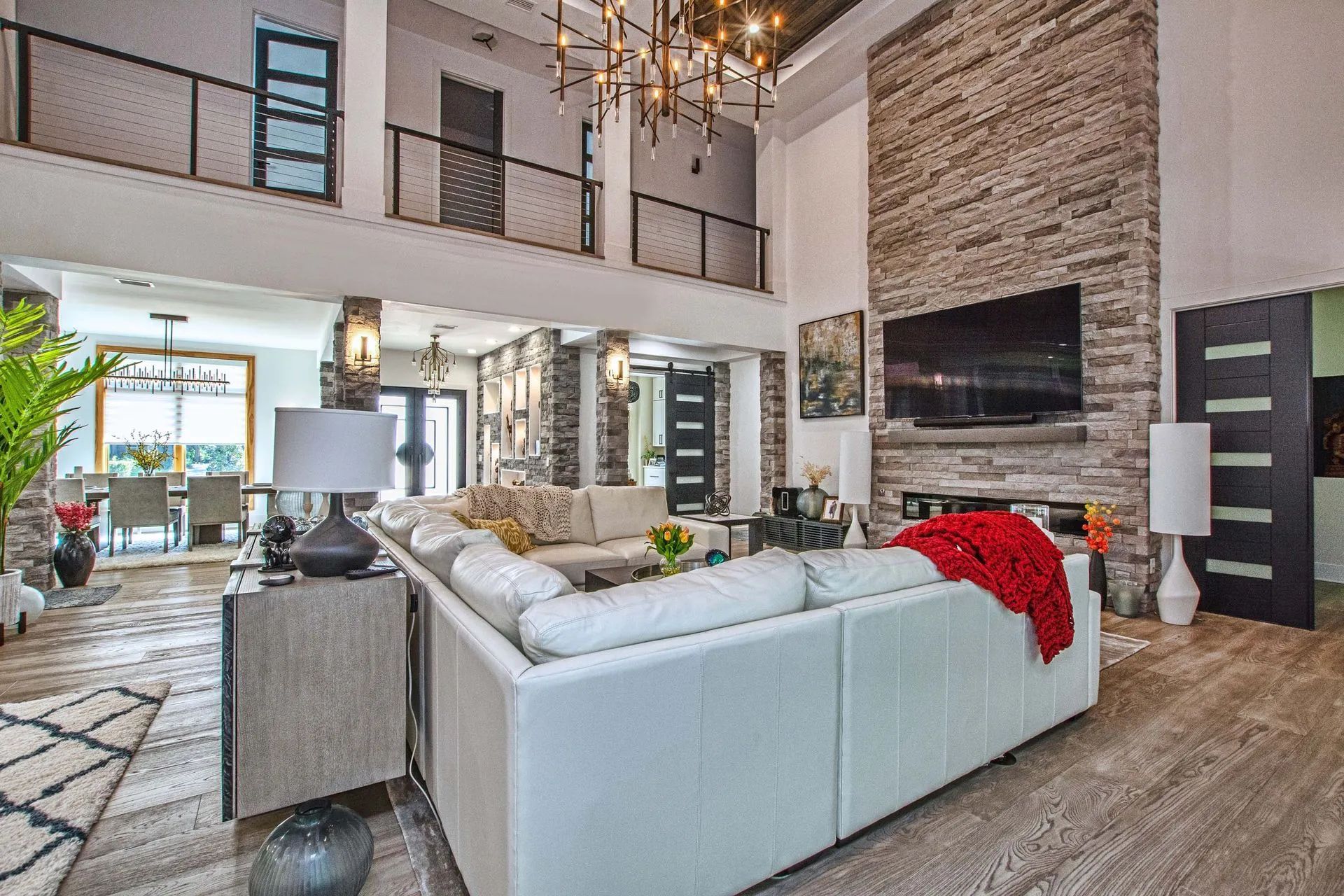 A living room with a large white couch and a flat screen tv.
