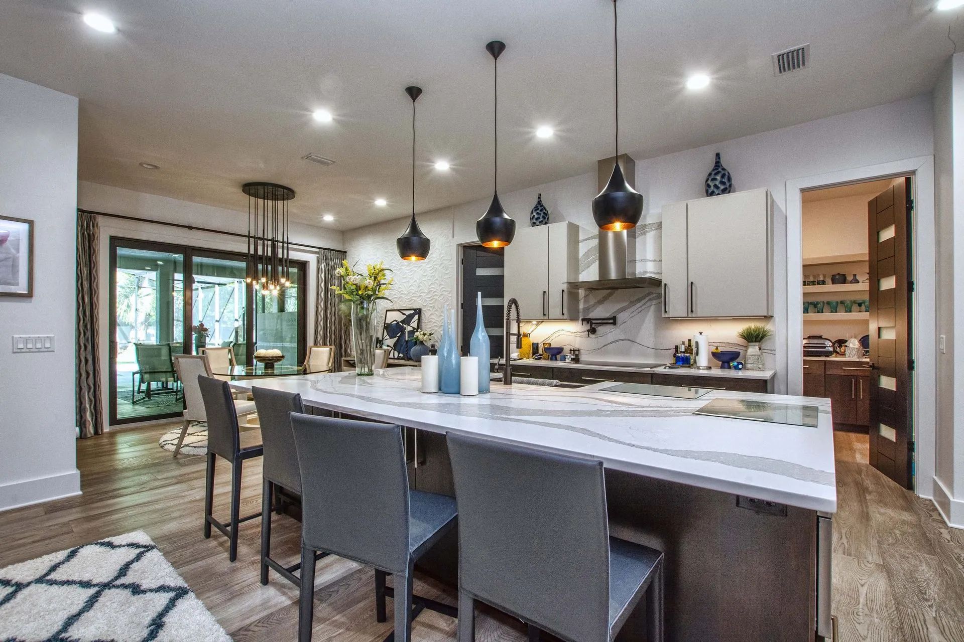 A kitchen with a large island and chairs in it