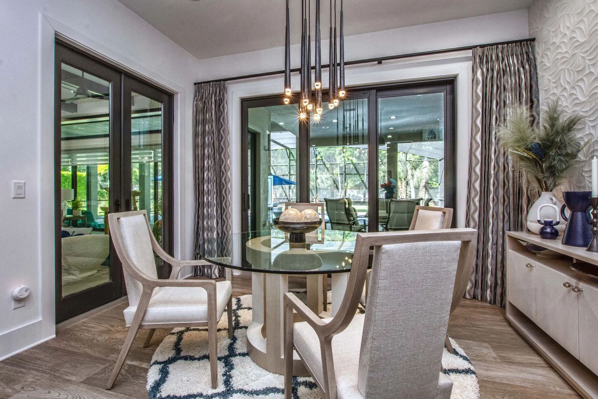 A dining room with a glass table and chairs and a chandelier.