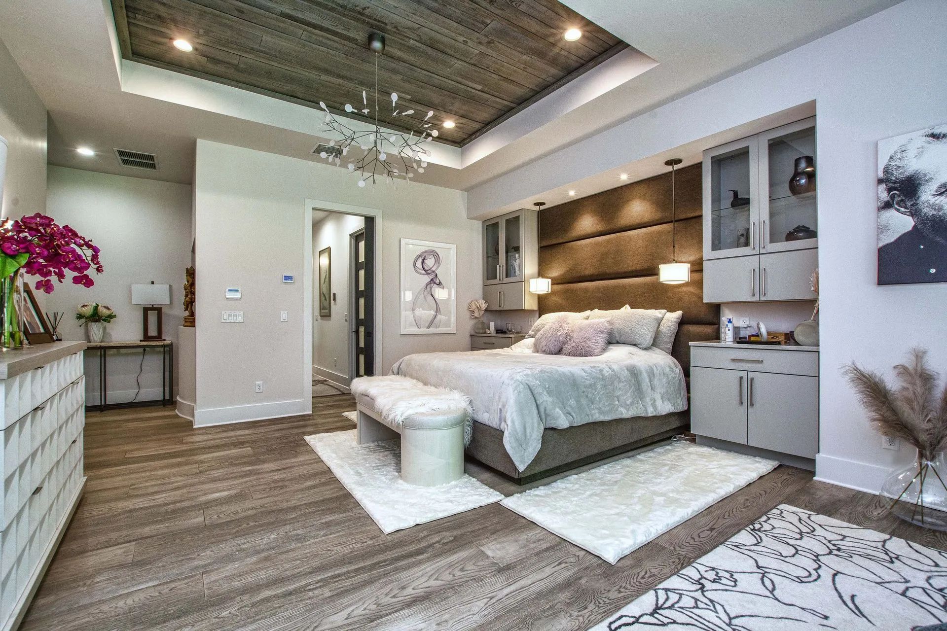 A bedroom with a large bed and a chandelier.