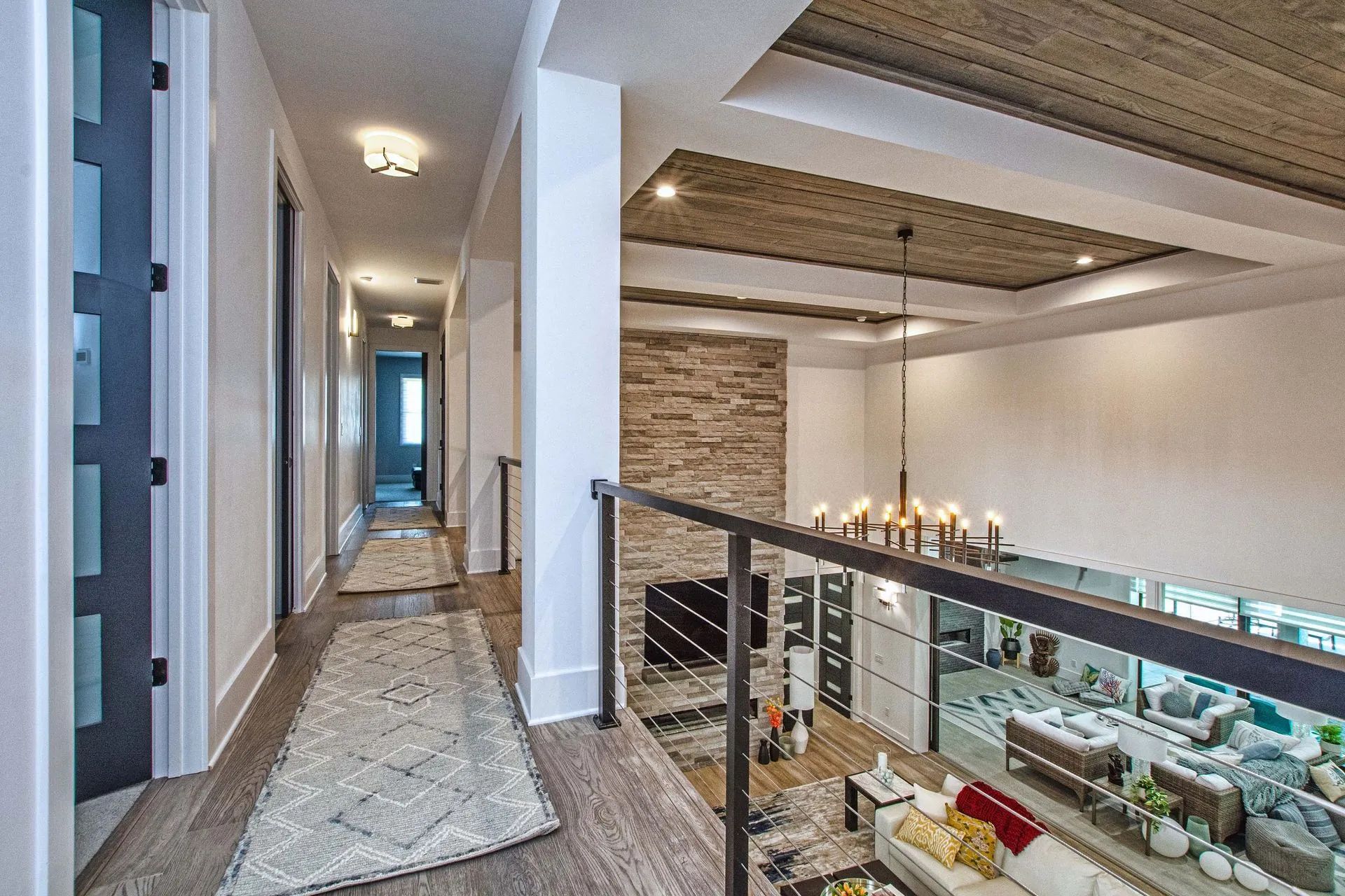 A hallway in a house with a balcony and a fireplace.