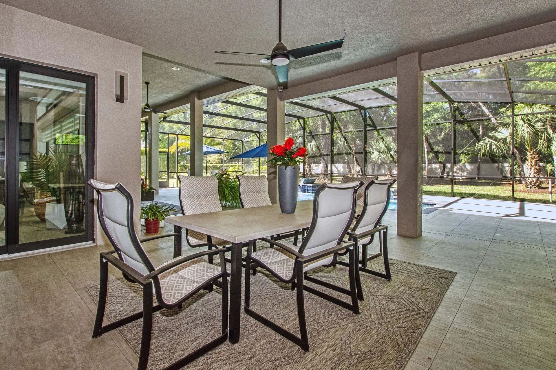 A patio with a table and chairs and a ceiling fan