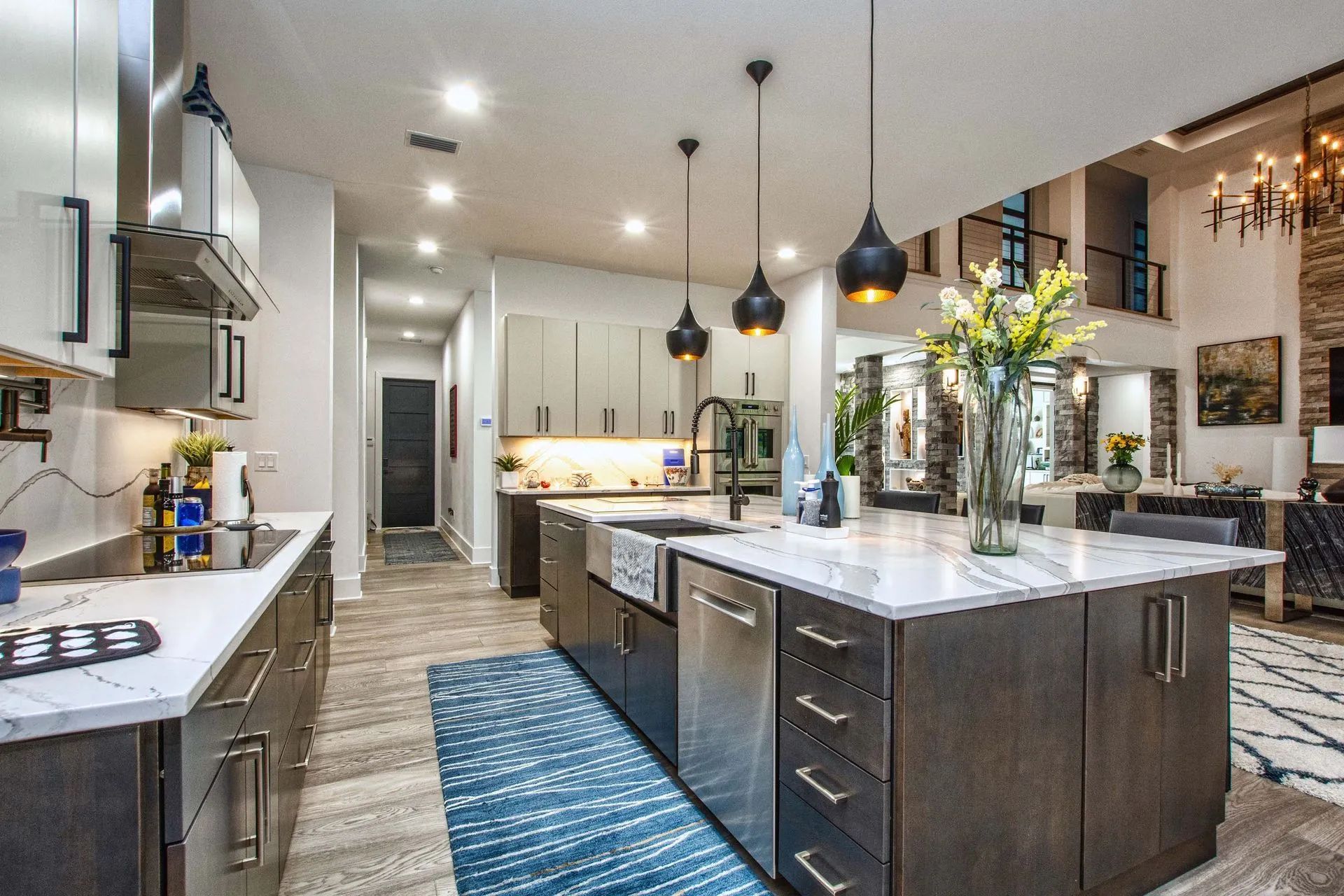 A kitchen with a large island in the middle and stainless steel appliances.