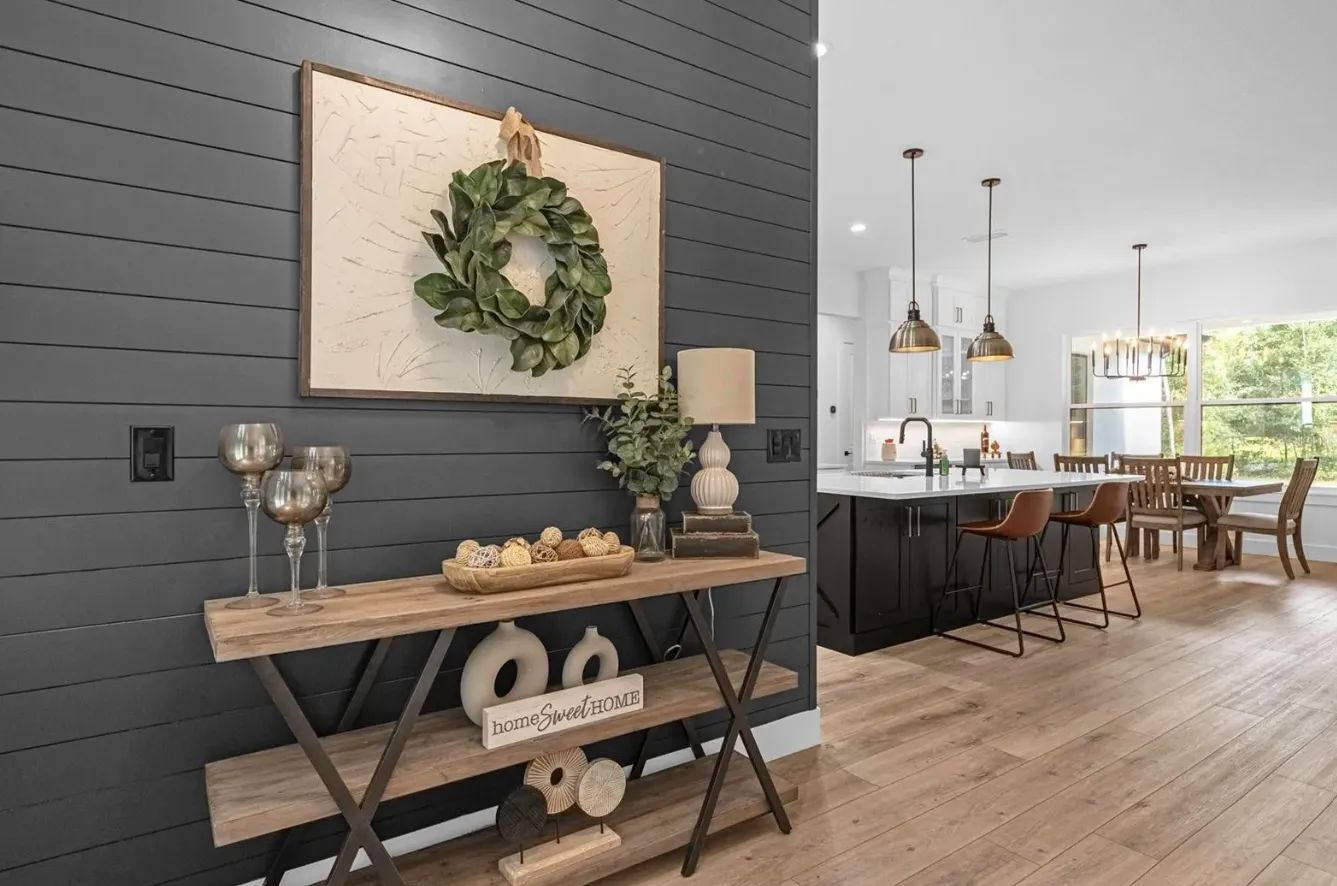 A living room with a wooden table and a painting on the wall.