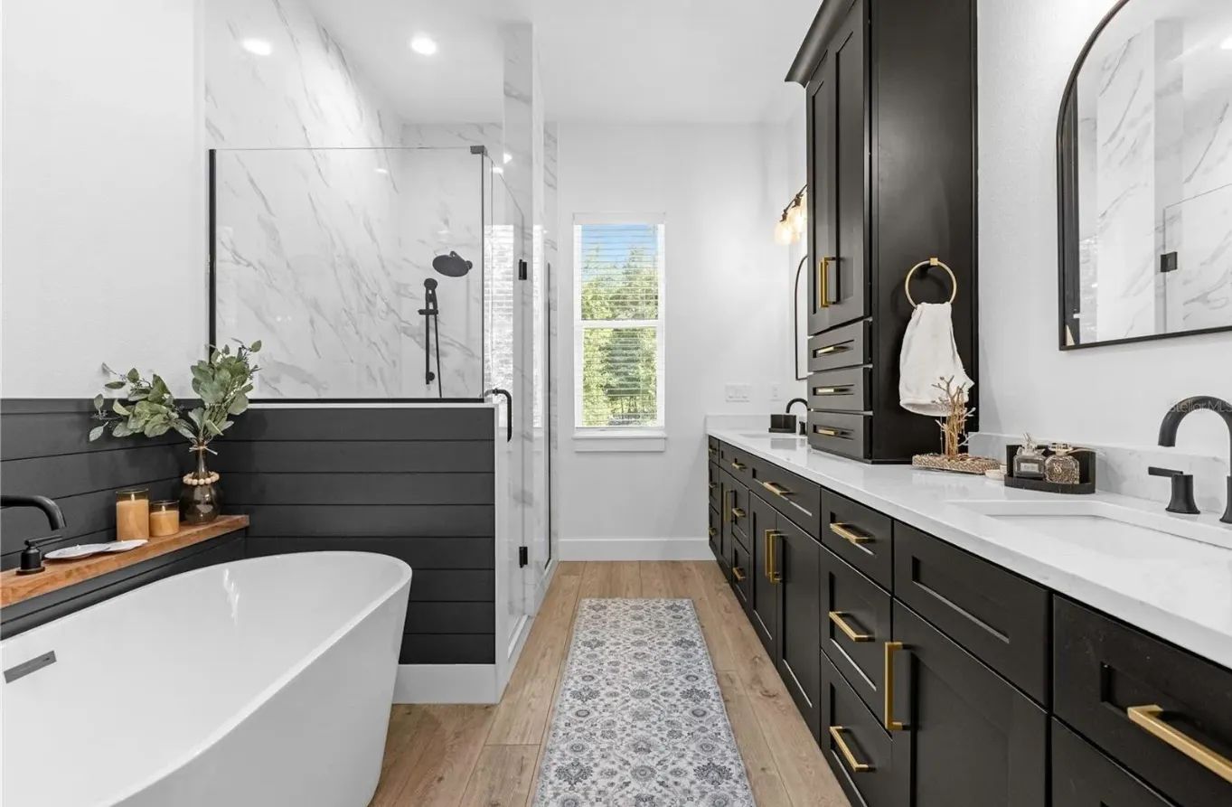 A bathroom with a bathtub, sink, and mirror.