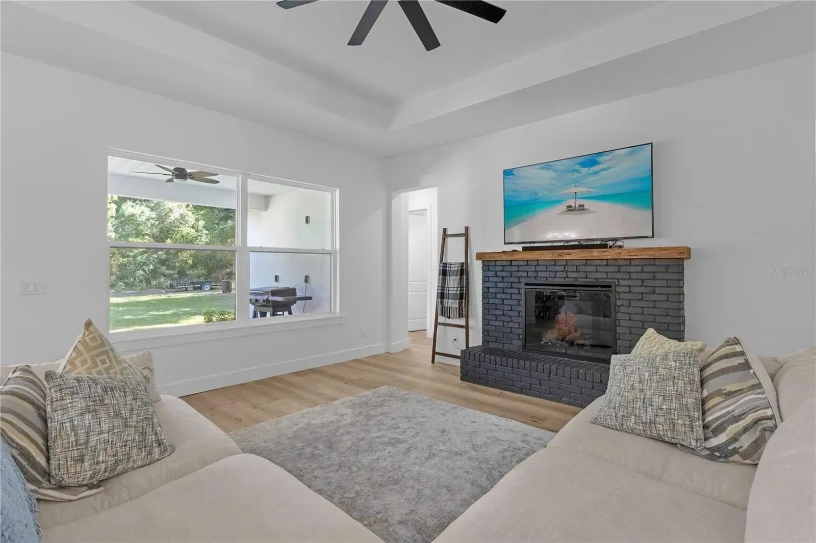 A living room with two couches, a fireplace and a flat screen tv.