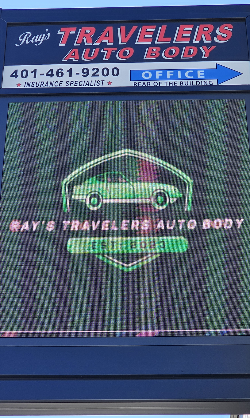 A digital LED sign for Ray's Travelers Auto Body with a car on it.
