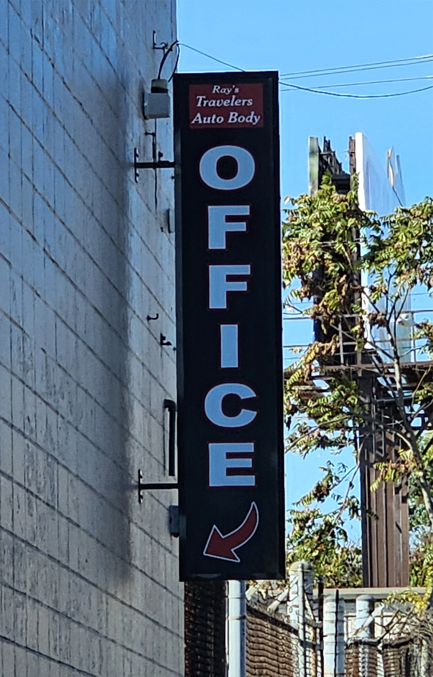 A Ray's Travelers Auto Body Office sign.