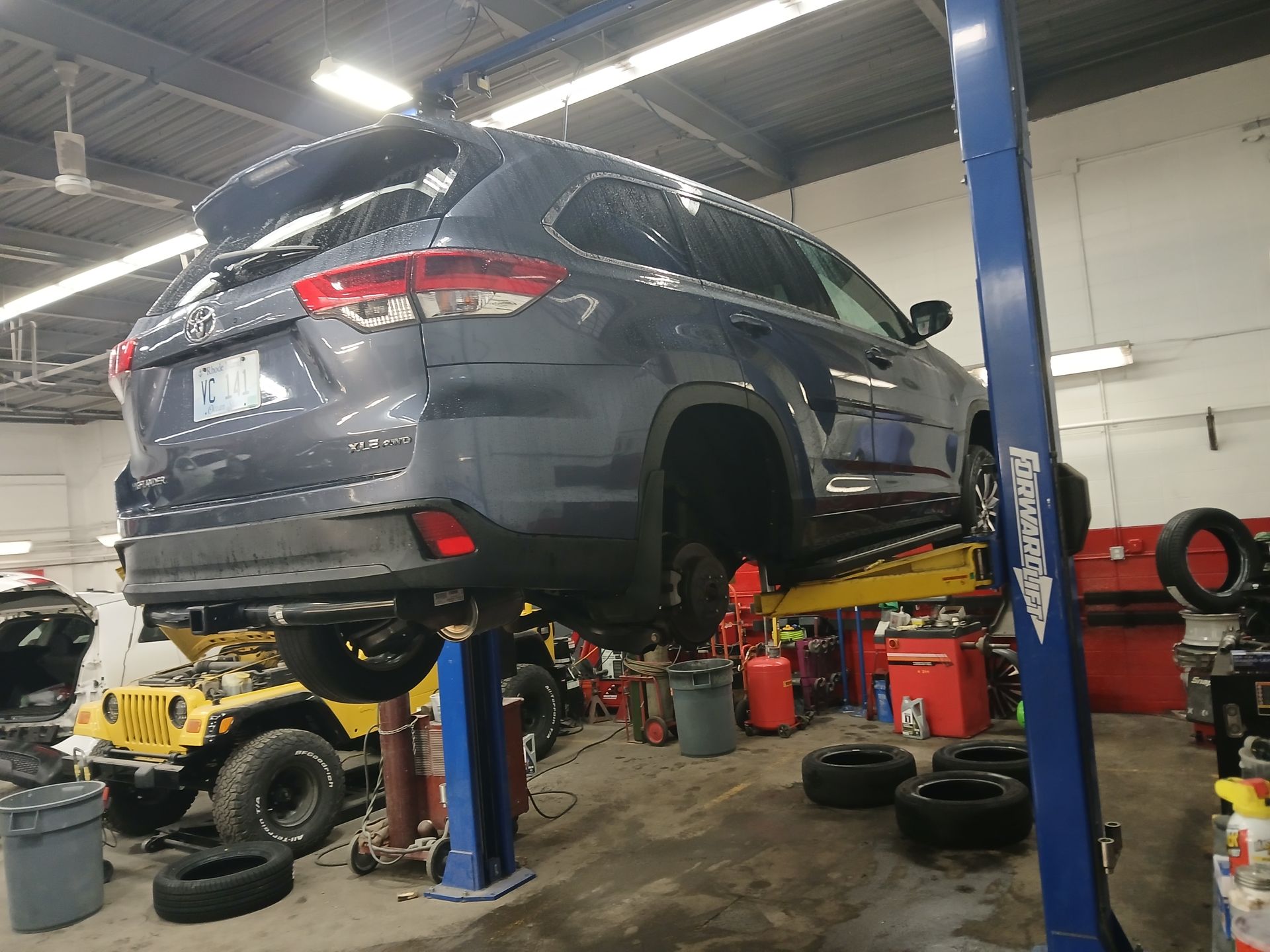 A car is sitting on a lift in a garage.