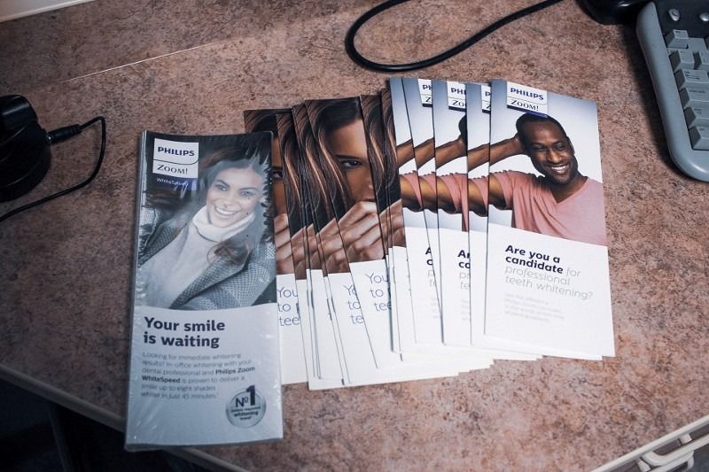 A stack of flyers that say your smile is waiting