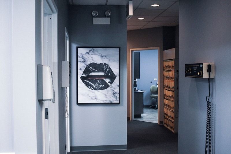 A hallway with a picture of a woman 's lips on the wall.