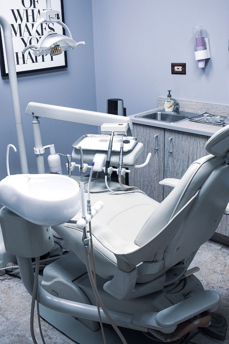 A dental chair in a dental office with a sign on the wall that says