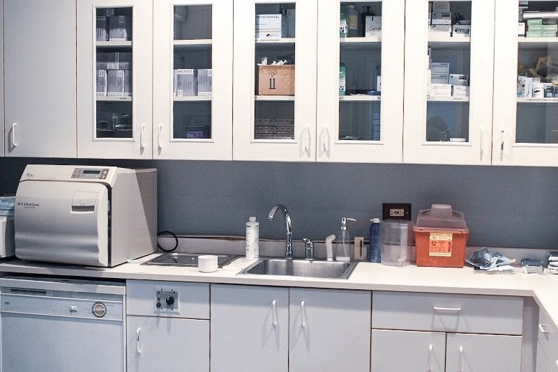 A kitchen with white cabinets and a sink