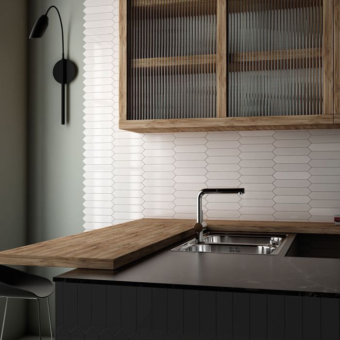 A bathroom with a sink , mirror , and purple tiles.