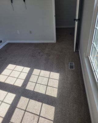 A room with a carpeted floor and a window
