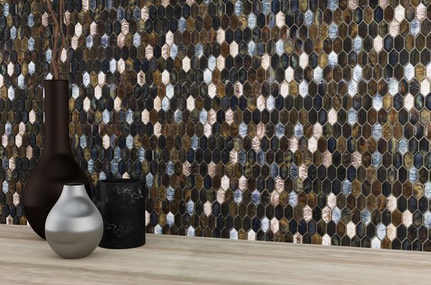 Two vases are sitting on a wooden table in front of a mosaic wall.