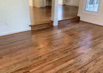 A living room with hardwood floors and white walls.
