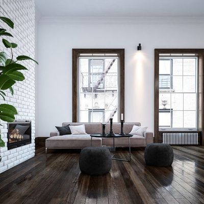 A living room with a couch , two tables , and a fireplace.