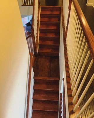 A wooden staircase with a white railing in a house