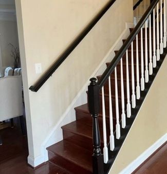 A staircase with a black wall and a white railing.