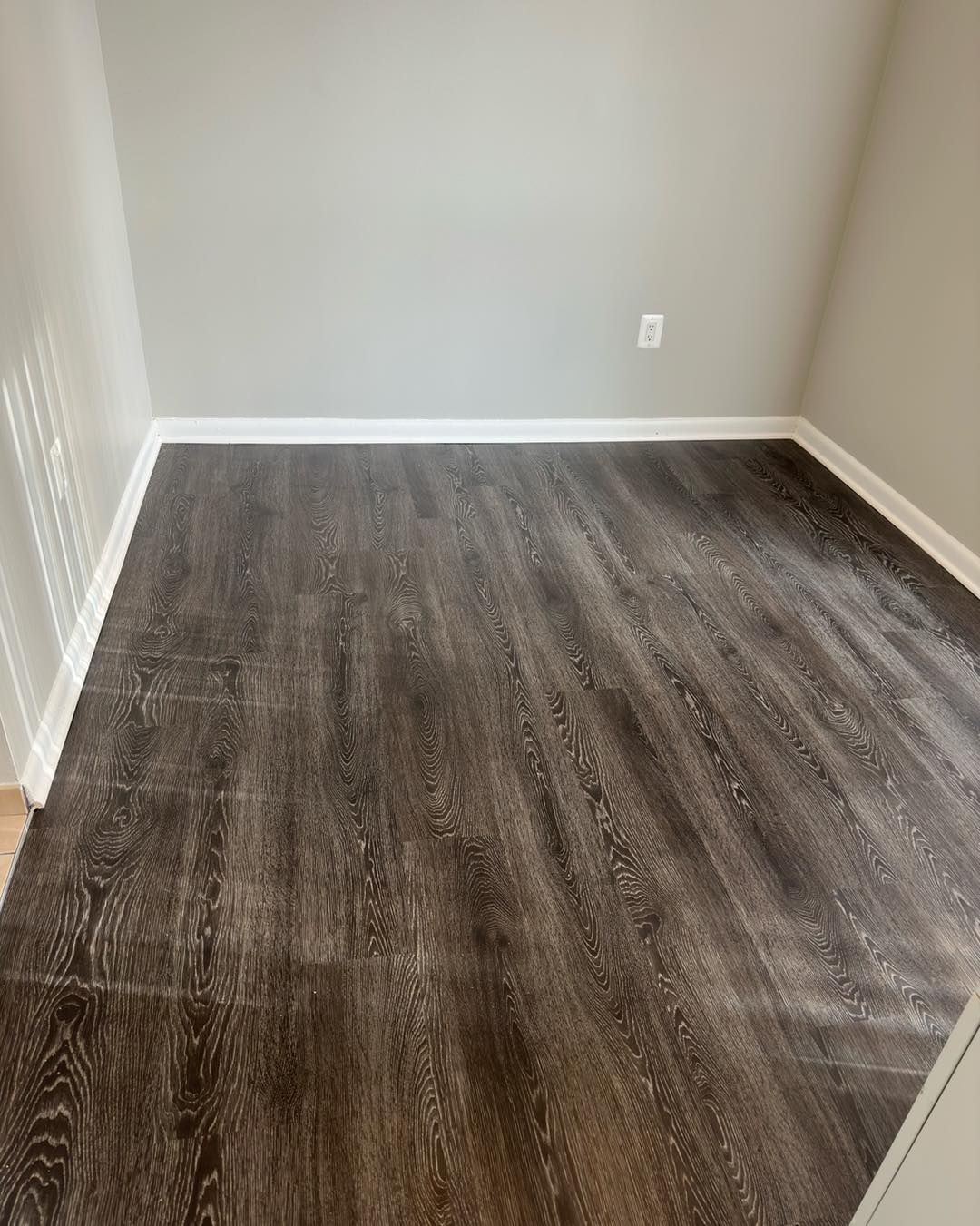 A room with a wooden floor and gray walls.