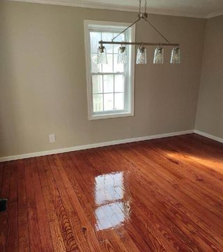 An empty room with hardwood floors and a window.