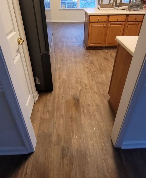 A kitchen with hardwood floors and wooden cabinets