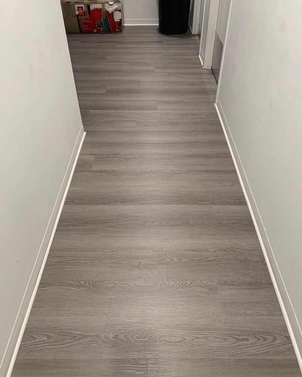 A bathroom with a toilet and a trash can on the floor.