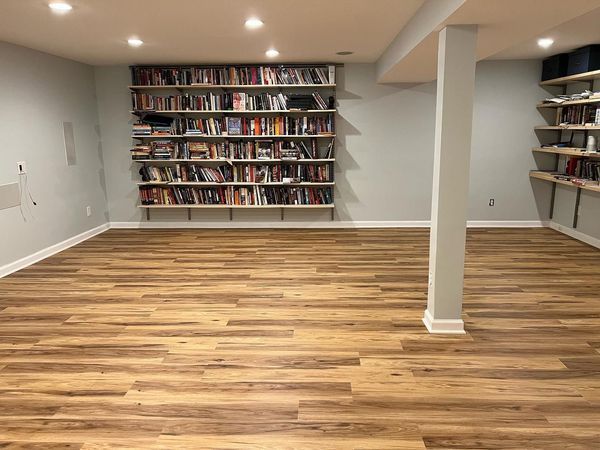 A room with hardwood floors and shelves filled with books.