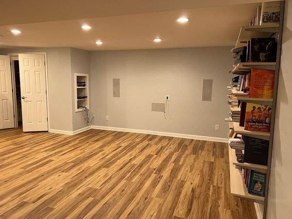A room with hardwood floors and shelves filled with books.
