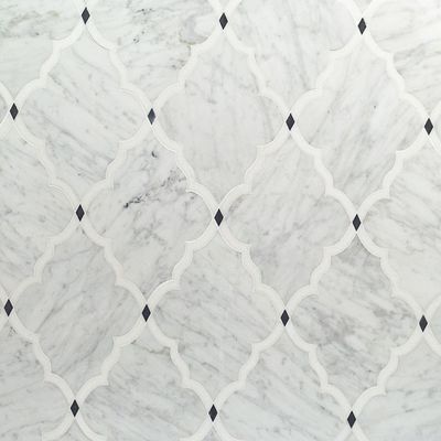 A close up of a white marble tile with a black and white pattern.